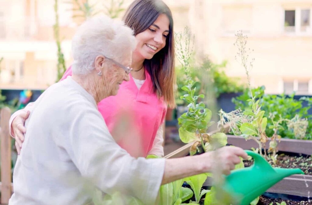 an older person gardening with a memory care aid.