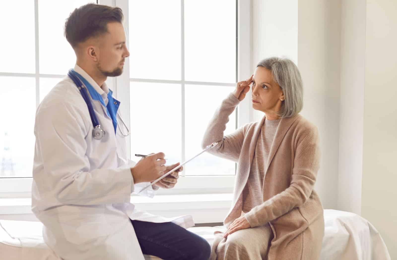 an older adult consulting with their doctor if it is time to transition to memory care.